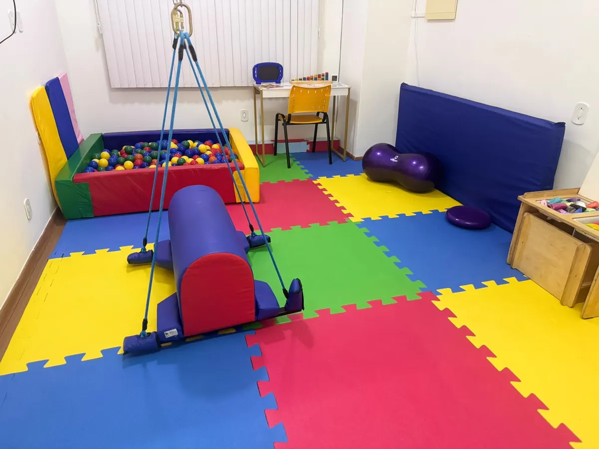 Sala de integração sensorial da Semear com piscina de bolinhas, balanço suspenso, bola de pilates e colchonetes